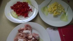Three plates of chopped food in preparation for cooking
