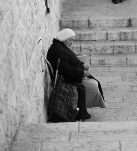 Black and White Image of a widow sitting next to a wall